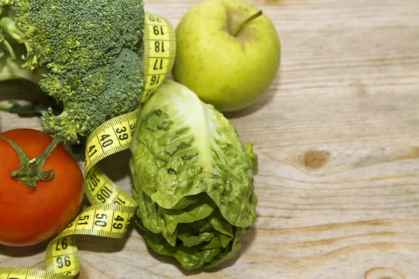 Tape measure with tomatoes, vegetables and apples