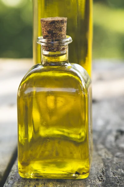 Bottles of olive oil on wood with green background
