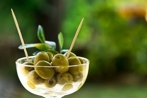 Glass cup green olives stuffed with background field