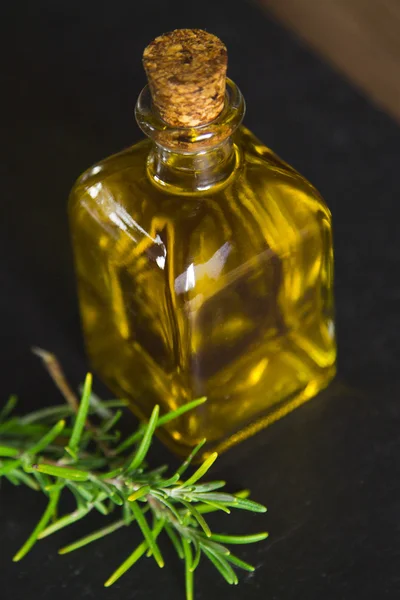Yellow oil bottle with rosemary