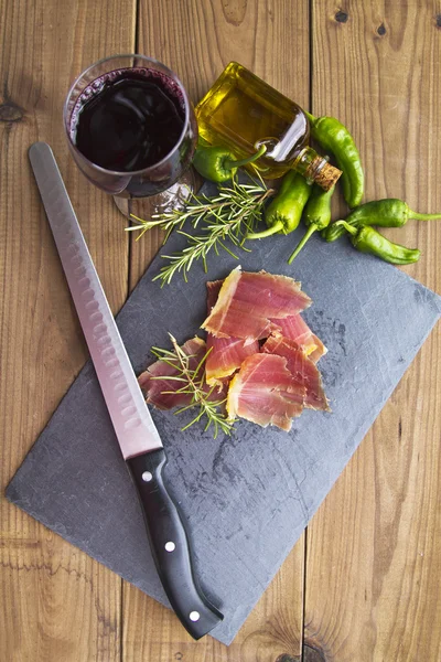 Serrano ham with rosemary oil and green peppers
