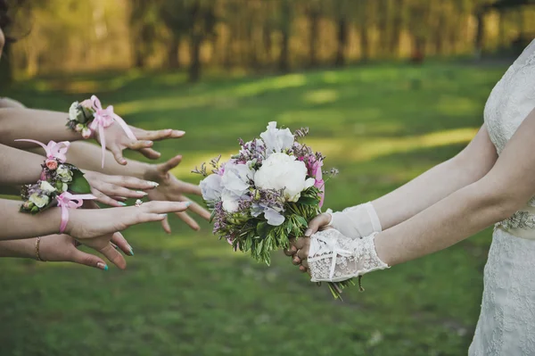 Hands reach to the brides bouquet 3929.