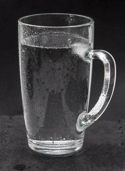 Misted glass of cold water, water the source of life. A refreshing Cup mineral or soda water, tonic with hissing bubbles. Isolated on a black background. Drinking water