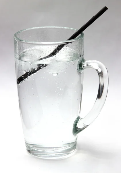 Drinking water. Daily drink a glass of very cold water, life giving water. Crystal clear water with ice in a transparent glass on a white background