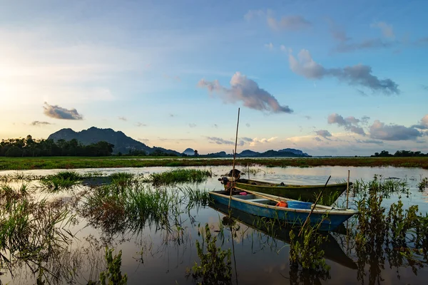 Majestic sunrise by the lakeside with fishing boats