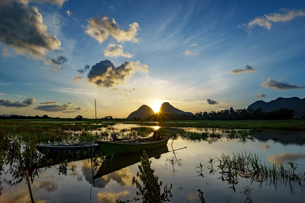 Majestic sunrise by the lakeside with fishing boats