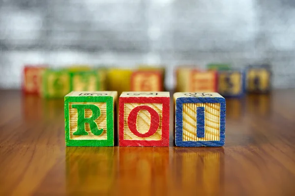 Word of ROI spelled with colorful wooden alphabet blocks.Selective focus,shallow depth of field.