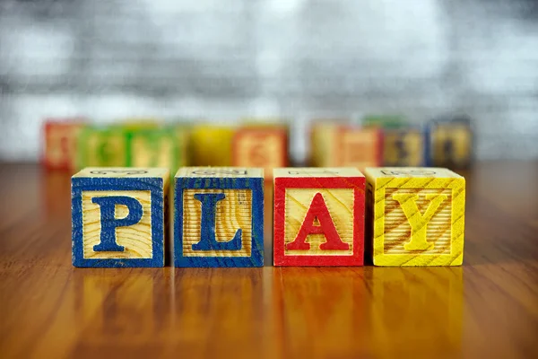 Word of PLAY spelled with colorful wooden alphabet blocks.Selective focus,shallow depth of field.