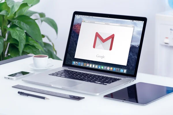 Google Gmail logo on Apple MacBook Pro display on office desk