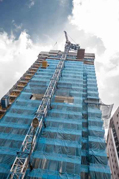 Crane at work on scaffold of tall building