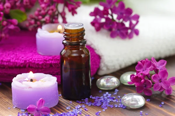 SPA setting with candles, aroma oil and lilac