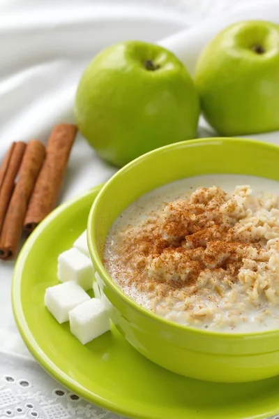 Healthy breakfast. Oatmeal with green apples, nuts and cinnamon.