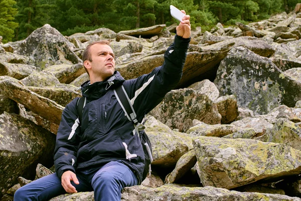 A young traveler man sit on the top of mountain in Prespa National Park  and enjoy the beauty of landscape near Bitola City.