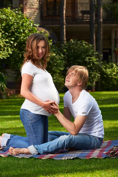 Pregnant couple resting in the park