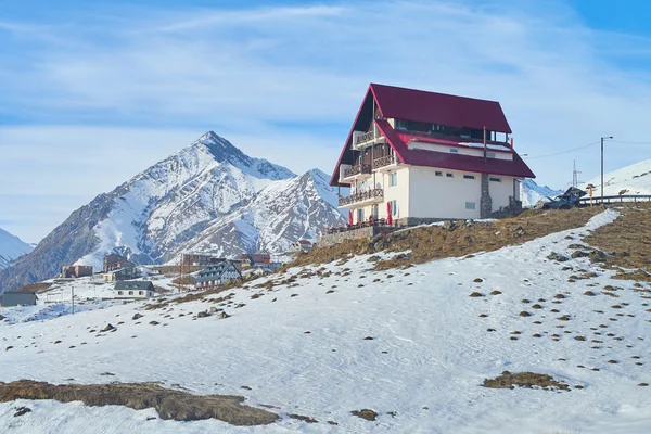 Modern mountains  ski resort on the top of the hill  with snowy peaks on the background in Georgia