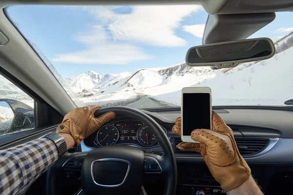 Man in car holding mobile phone