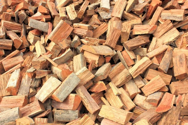 Close up of roughly split firewood heap textured background