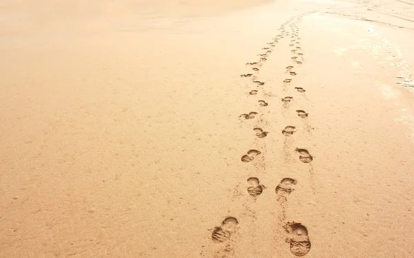 Minimalistic beachscape of two sets of foot prints in sand