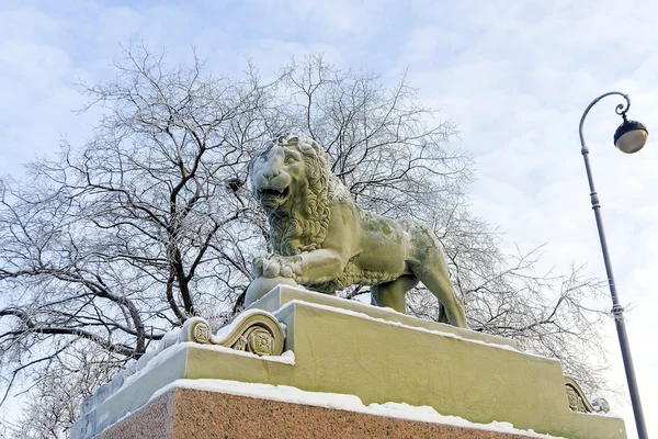 Winter embankment of the Neva River, snow lion statues
