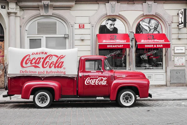 PRAGUE, CZECH REPUBLIC-MAY 15: a red retro car Ford F-100 with advertising inscription Coca Cola on board on the streets of Prague\'s Old Town May 15, 2015