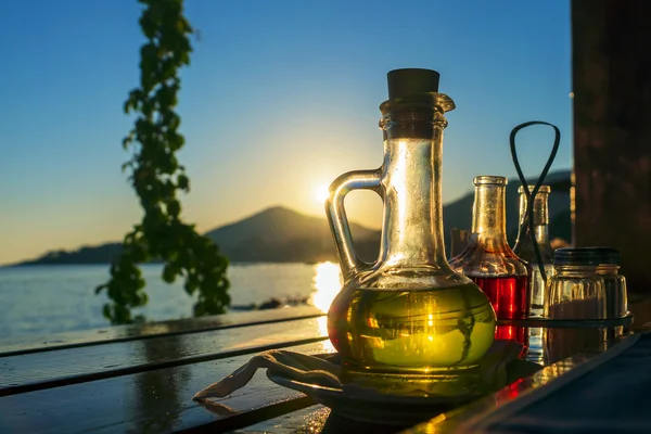 Bottle with olive oil on a background of sea sunset