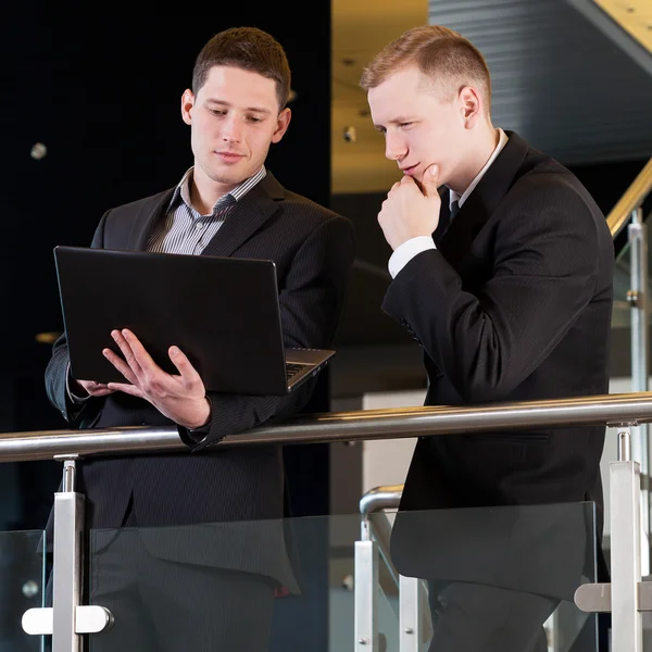 Business people looking at laptop