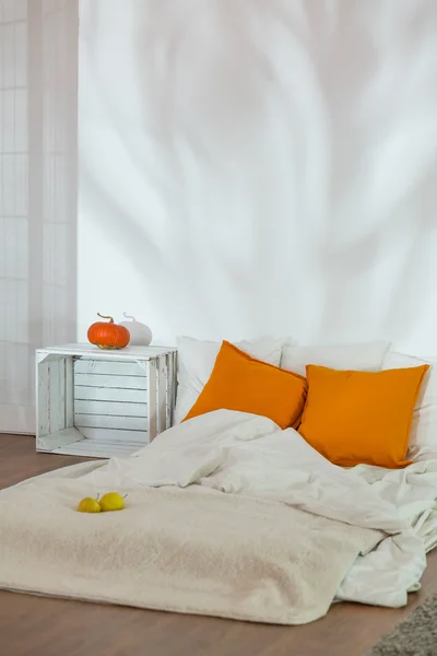 Unmade bed in simple autumn bedroom