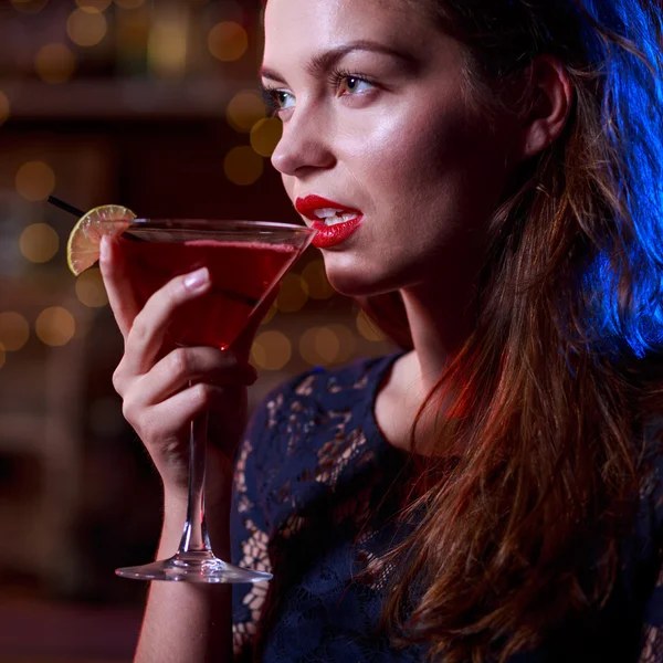 Woman in black dress drinking