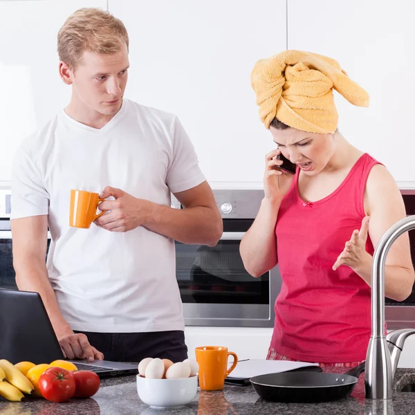 Busy couple in the morning in kitchen