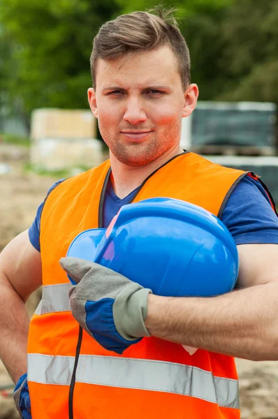 Worker holding blue safety helmet