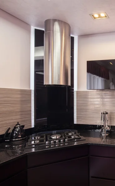 Dark kitchen with chromed hood