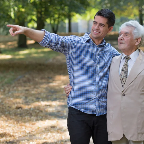 Young man showing something grandfather