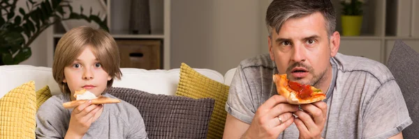 Father and son eating pizza