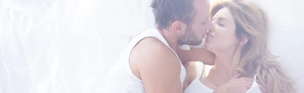 Romantic couple kissing in bed