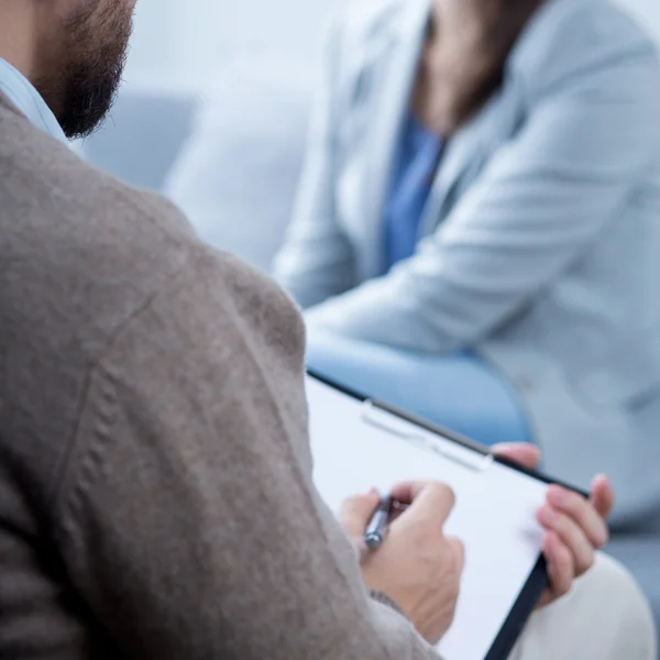 Male psychotherapist talking with woman