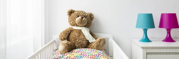 Teddy bear in a crib