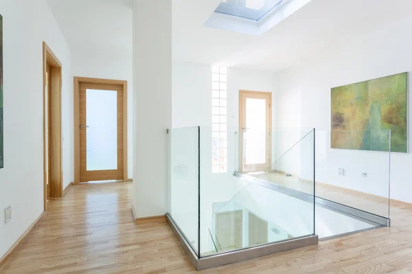 Stairs, glass banister and doors in modern hallway