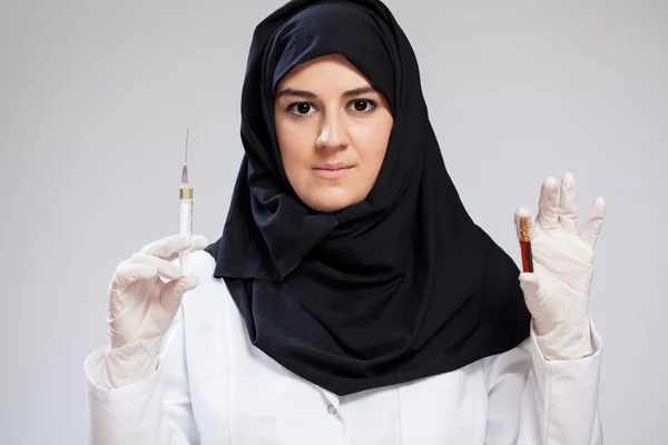 Muslim nurse holding syringe