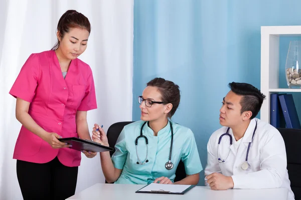 Asian and caucasian doctors during job
