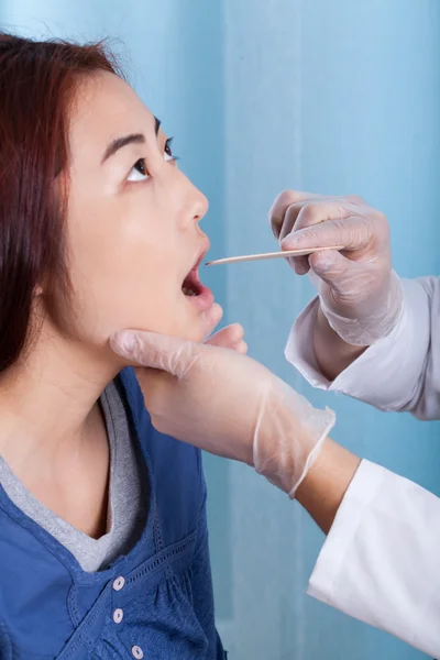 Mongolian woman during throat examination