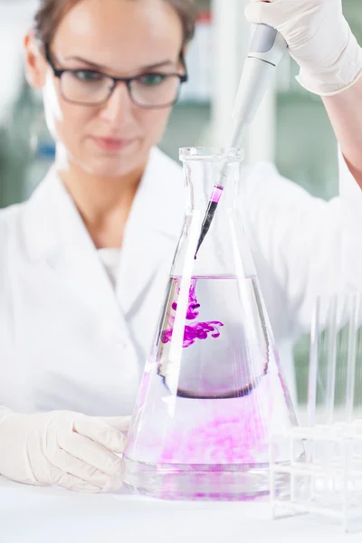 Chemist putting purple liquid