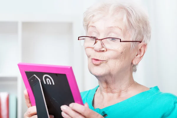 Elderly woman holding frame