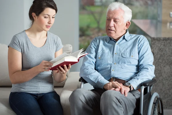 Senior care assistant reading book