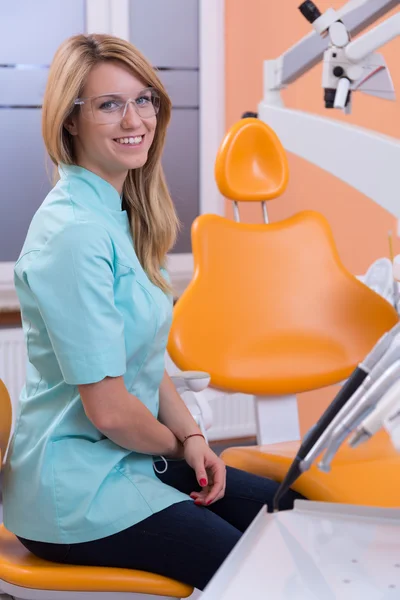 Dentist sitting on dental stool