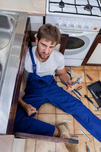 Upset plumber trying to fix the sink