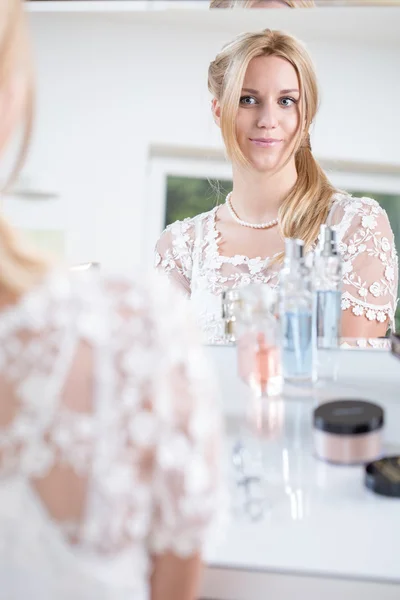 Bride looks at herself in the mirror