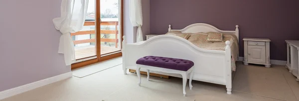Purple bedroom with white furniture