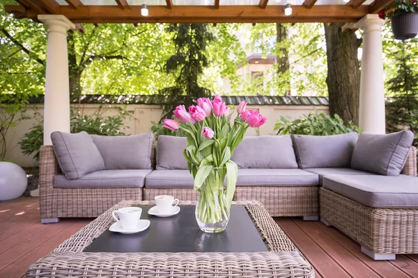 Large sofa and beautiful flowers on table