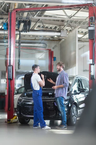 Auto mechanic talking with client