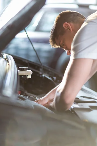 Automobile mechanic repairing a car